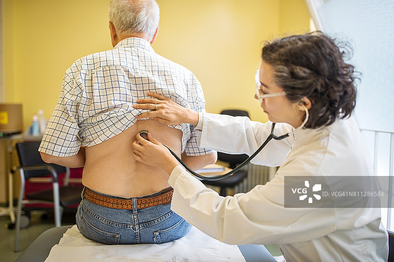 医生用听诊器检查病人背部图片素材