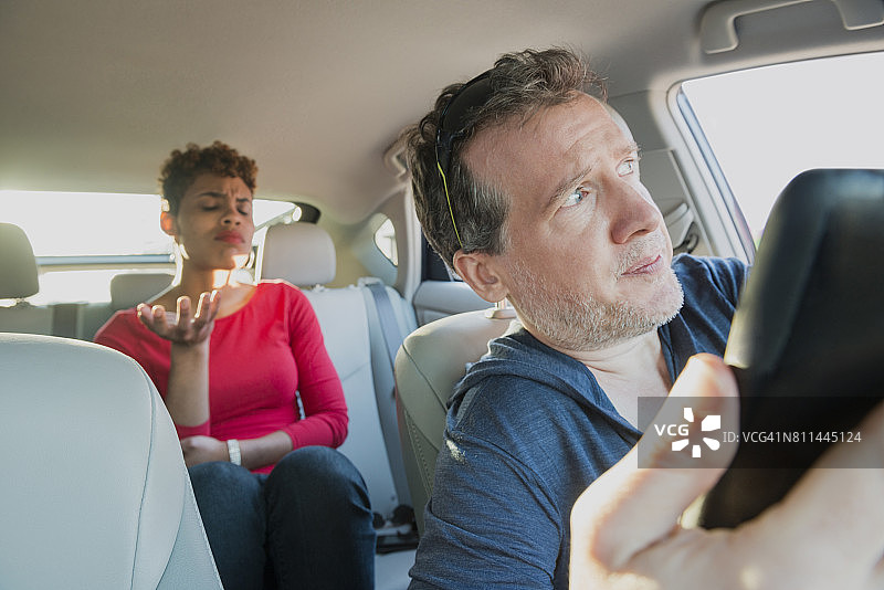 愤怒的千禧一代乘客向迷路的司机抱怨图片素材