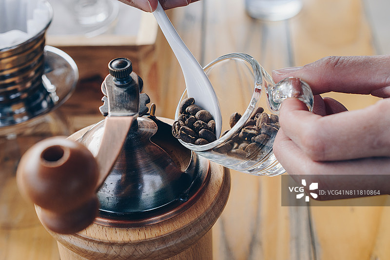 咖啡师准备咖啡豆放入咖啡研磨机中进行研磨图片素材
