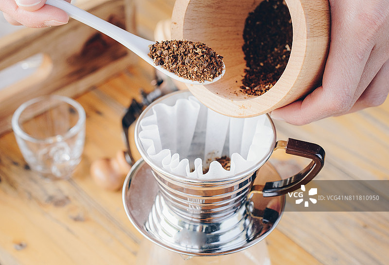 咖啡师将咖啡粉倒入滤纸准备冲泡图片素材