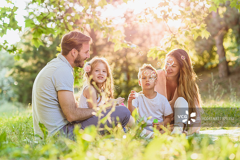 在野餐吹肥皂泡的家庭图片素材