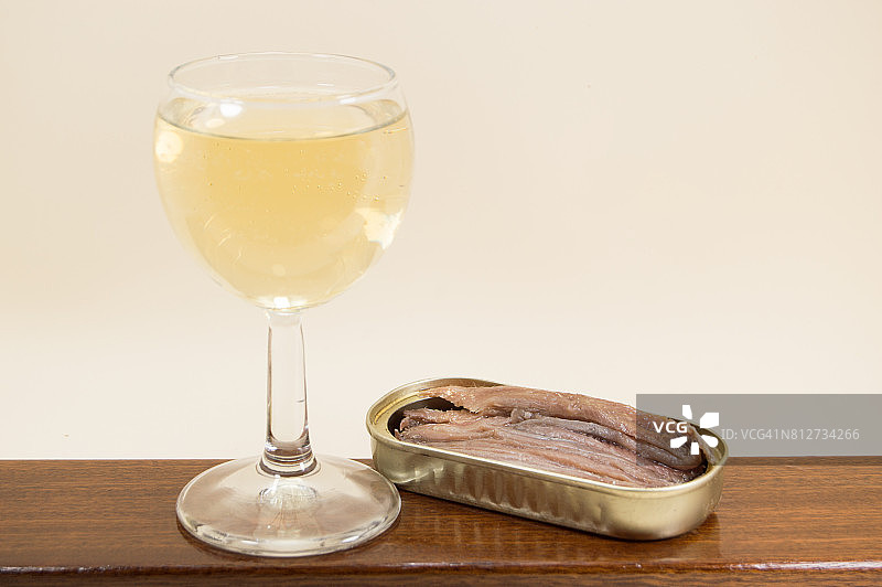 橄榄油浸凤尾鱼罐头和白葡萄酒杯图片素材