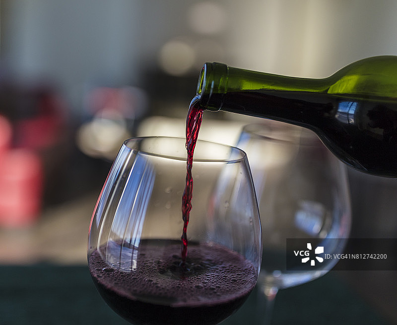 红酒从瓶中倒入玻璃杯的特写图片素材