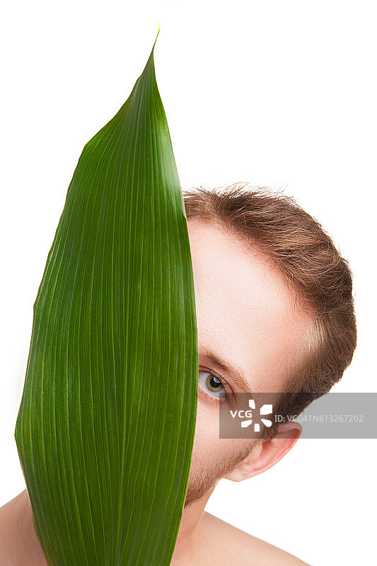 男子从树叶中向外看图片素材