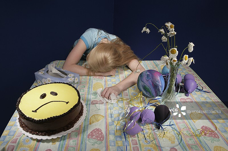 被聚会用品包围的沮丧女孩图片素材