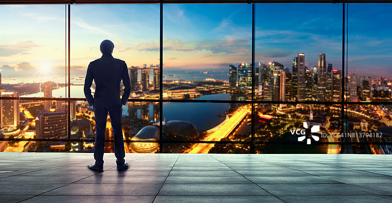 从办公室窗口看城市景观的商人图片素材