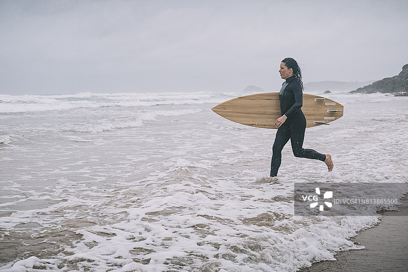 冲浪女子奔向大海，英国康沃尔郡图片素材