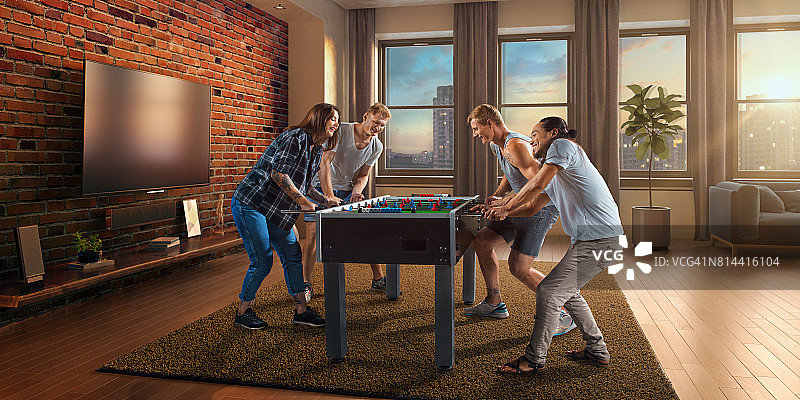 朋友们兴致勃勃地玩桌上足球游戏图片素材