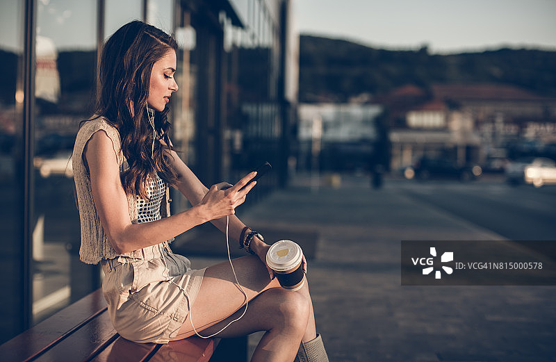 在建筑物前发短信的年轻女人图片素材