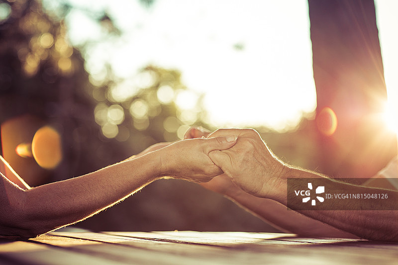 老年夫妇坐在公园长椅上欣赏日落图片素材