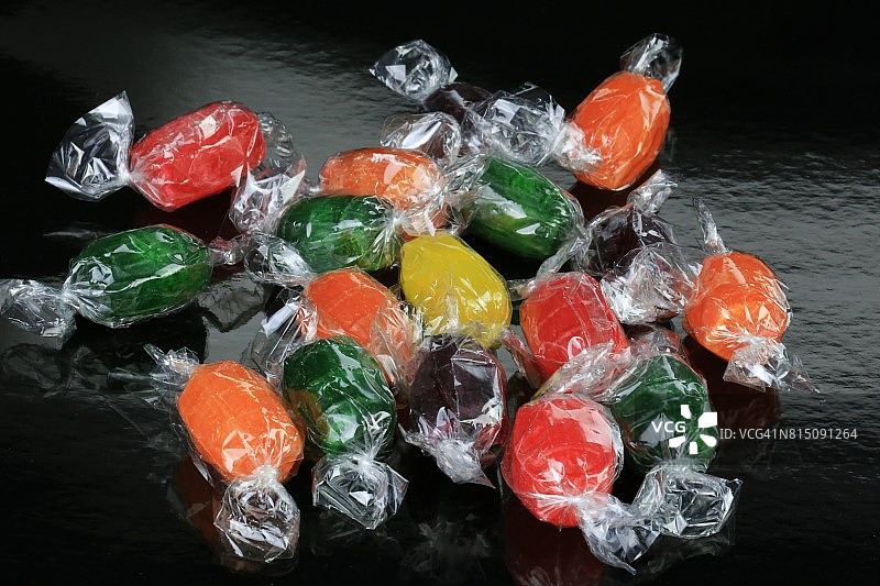 黑色背景上的水果味糖果图片素材