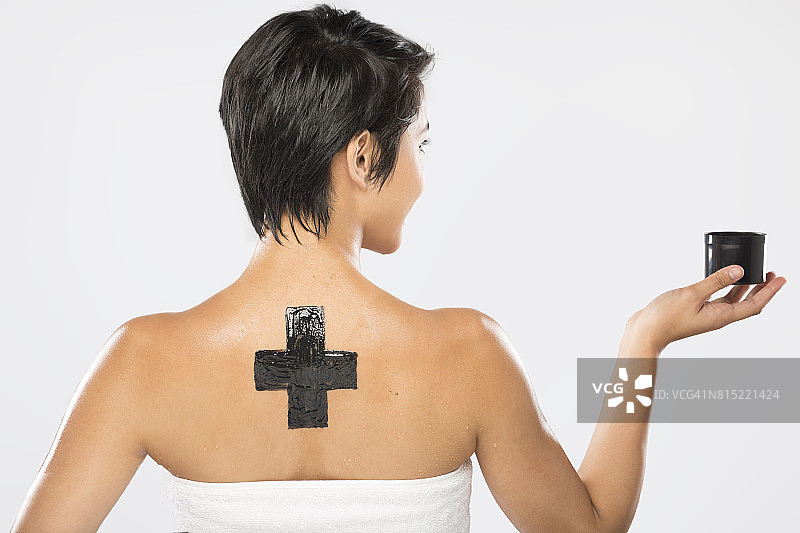 身材苗条的菲律宾女子，短发，展示黑色面具和黑色十字架图片素材