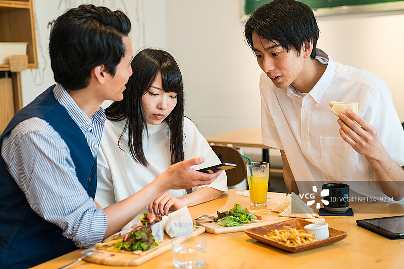 一群朋友在咖啡馆里使用智能手机图片素材