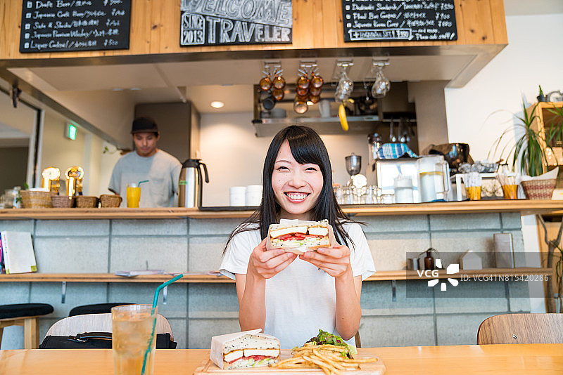 在咖啡馆里准备吃三明治的年轻女孩图片素材