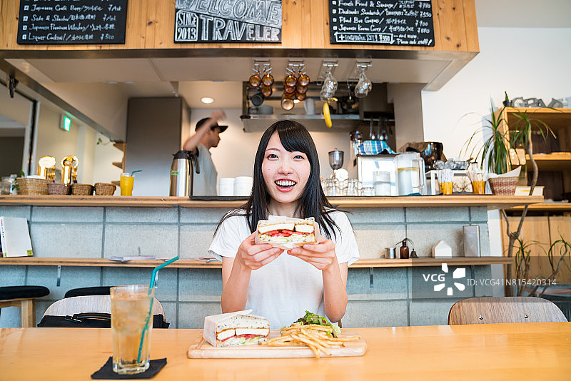 在咖啡馆里准备吃三明治的年轻女孩图片素材