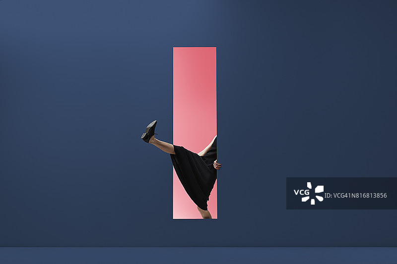 女人穿过彩色墙壁的矩形开口图片素材