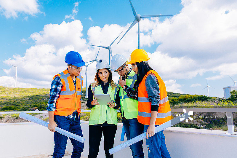 年轻工程师和工人在风电场开会图片素材