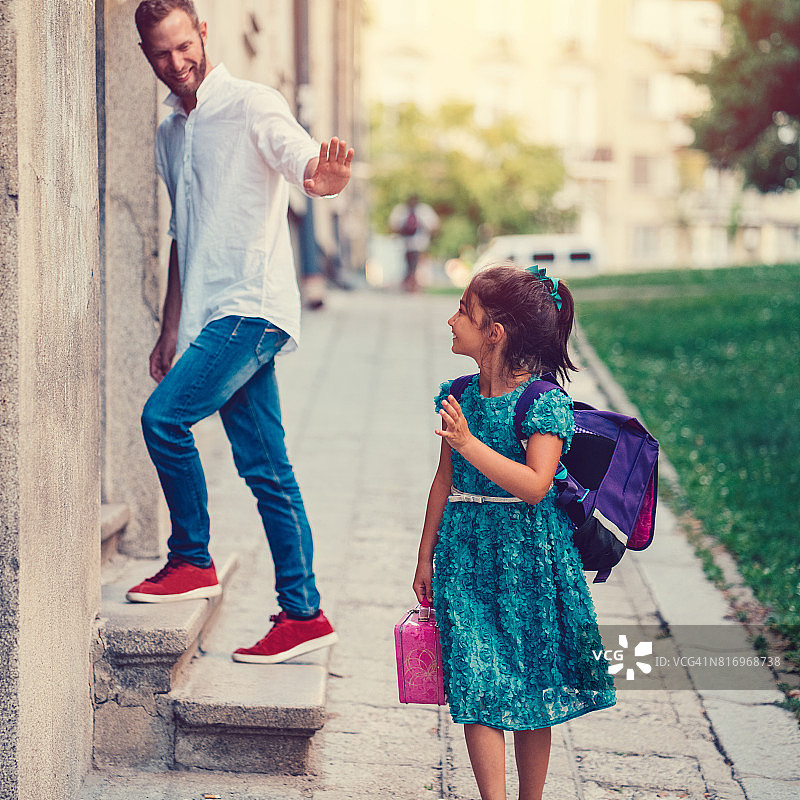 小女孩去上学，向父亲挥手图片素材
