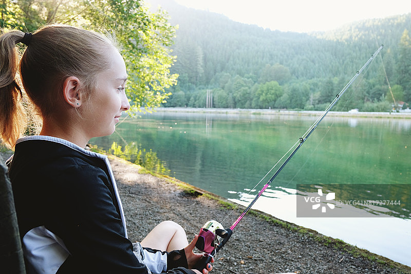 在水边钓鱼的青少年女孩图片素材