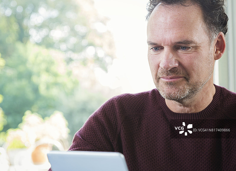 在厨房使用平板电脑的商务男士图片素材