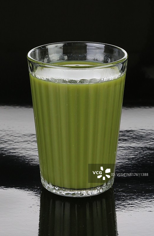 盛有绿色蔬菜健康果汁的透明玻璃杯图片素材