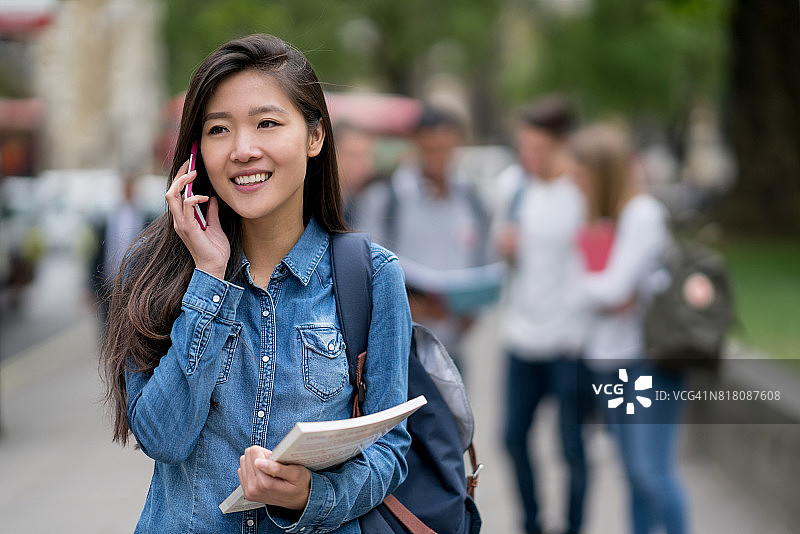 亚洲学生在户外打电话图片素材