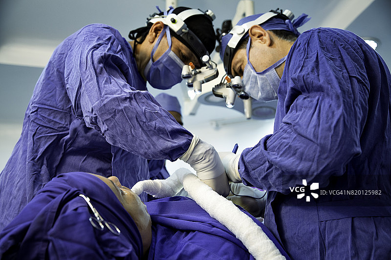 外科医生为女性患者进行肋软骨切取术，治疗鼻中隔偏曲和隆鼻手术图片素材