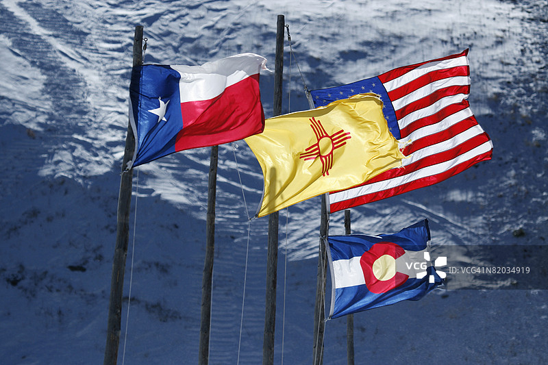 德克萨斯州、新墨西哥州、科罗拉多州和美国国旗在雪山背景中飘扬图片素材