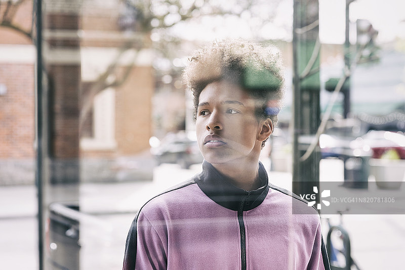 透过窗户看到的城市街道上的少年图片素材