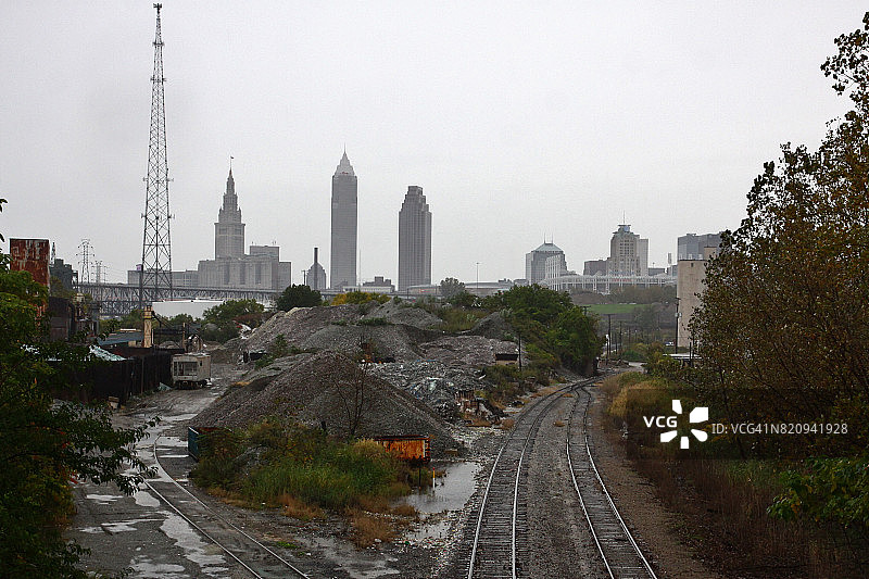通往多云城市天际线的工业铁路图片素材
