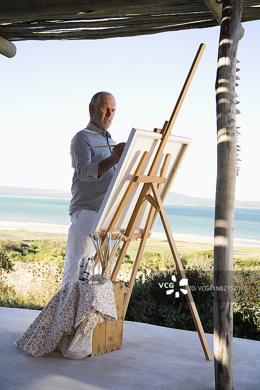 在户外使用画架和颜料的油漆匠图片素材