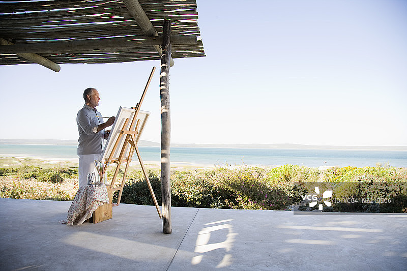在户外使用画架和颜料的油漆匠图片素材