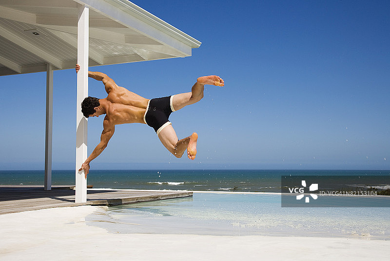 男人在海边阳台上荡秋千图片素材