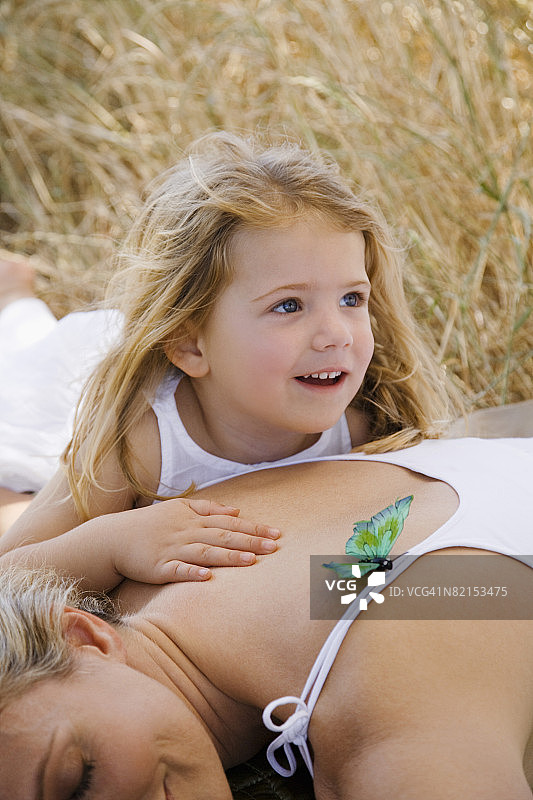 女孩躺在田野里母亲的怀里图片素材