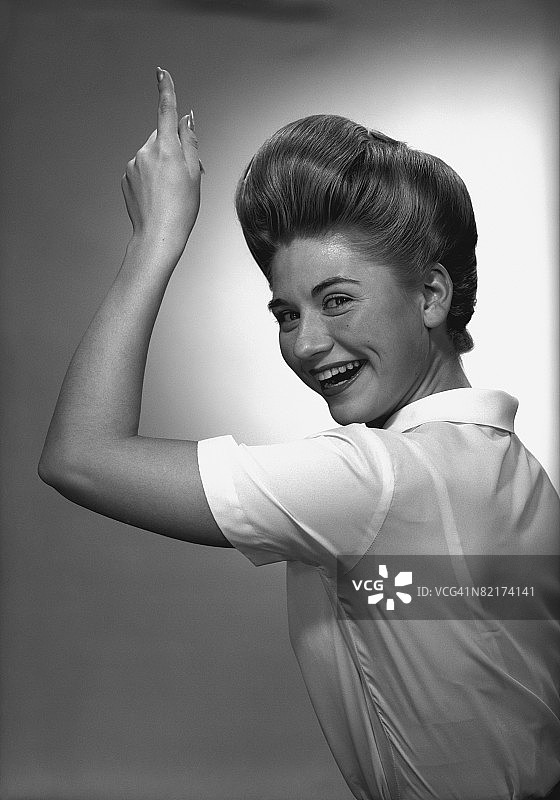 黑白肖像：在工作室向上指的女人图片素材