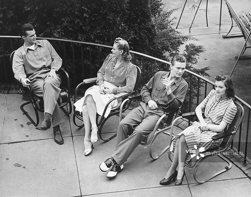 两对情侣在露台上放松（黑白照片），高角度拍摄图片素材