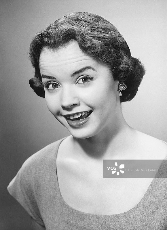 微笑的女人在工作室摆姿势（黑白肖像）图片素材