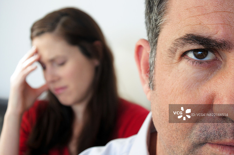 悲伤的妻子坐在丈夫身后图片素材