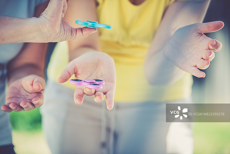两名妇女手中拿着指尖陀螺特写图片素材