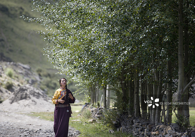 在草原村庄漫步的藏族女孩图片素材
