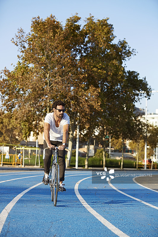 男子在跑道上骑自行车的全身照图片素材