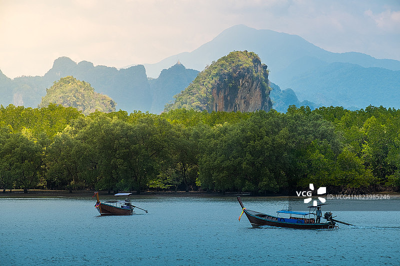泰国南部，长尾船在热带海域的日落美景图片素材