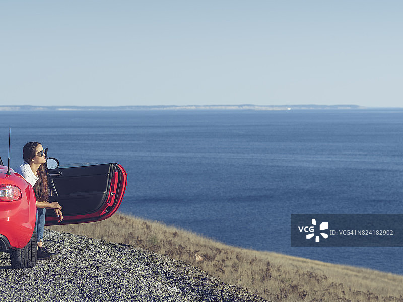 坐在红色敞篷车里的漂亮女孩图片素材