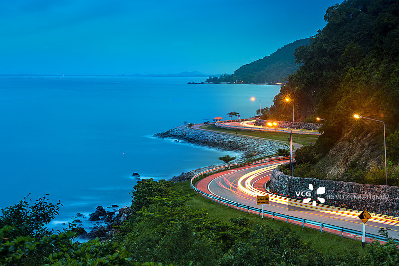 海边的公路，黄昏时分有车辆经过的光迹图片素材