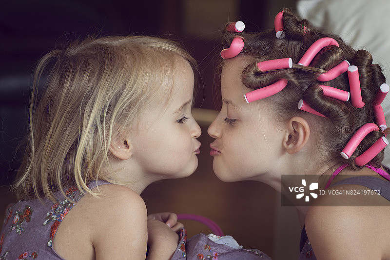 穿粉色旱冰鞋的女孩亲吻妹妹图片素材