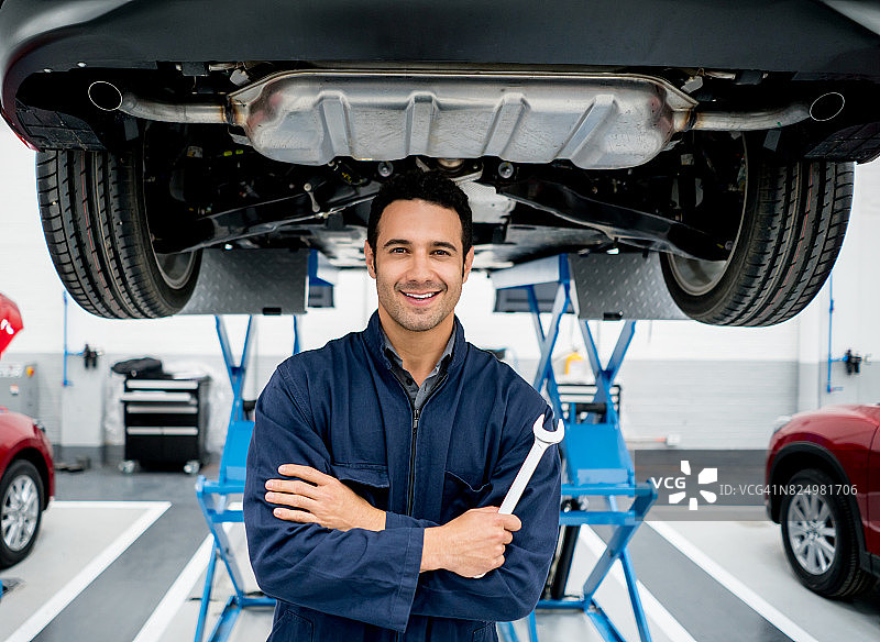 在汽车修理厂工作的快乐技工图片素材