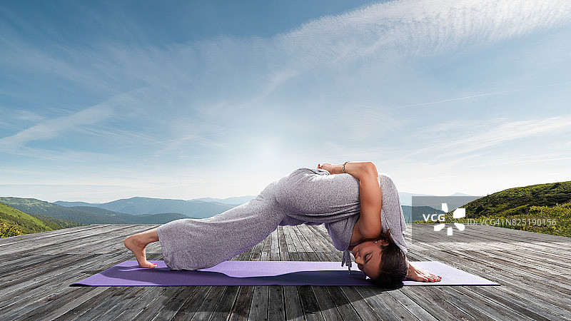 在户外练习瑜伽的年轻漂亮女人：三角形图片素材