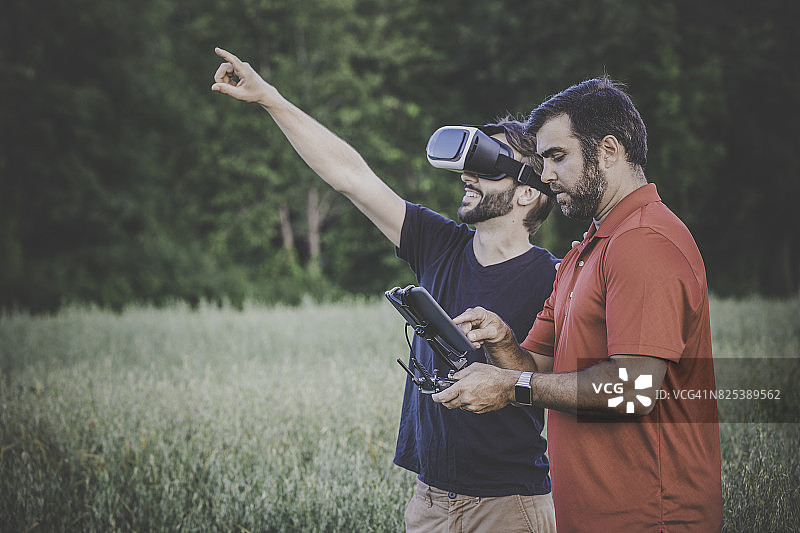 朋友们在户外使用无人机和VR头显图片素材