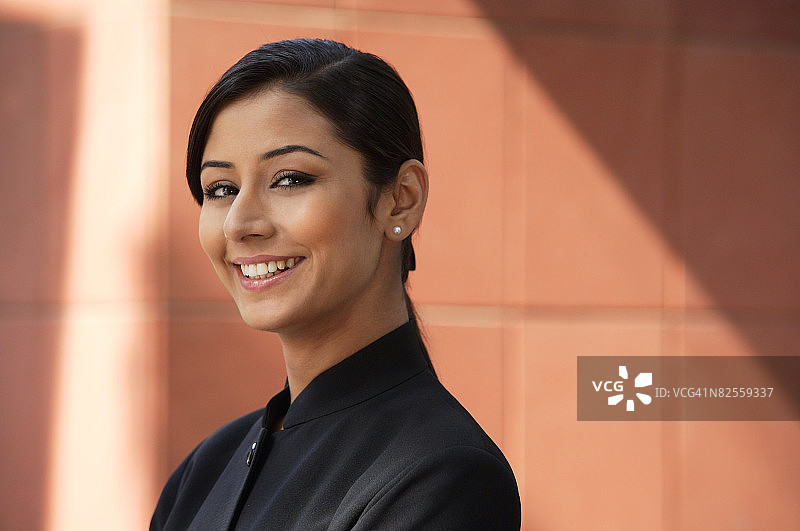 戴着珍珠耳环对着镜头微笑的女人（横版）图片素材