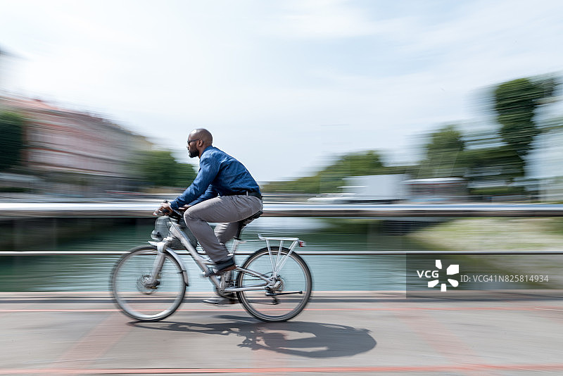 骑着城市自行车的商人穿梭于城市中图片素材